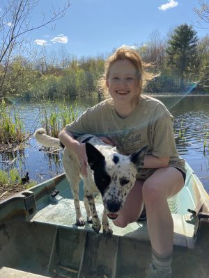 Sage Ganshirt smiling with black & white  dog at lake